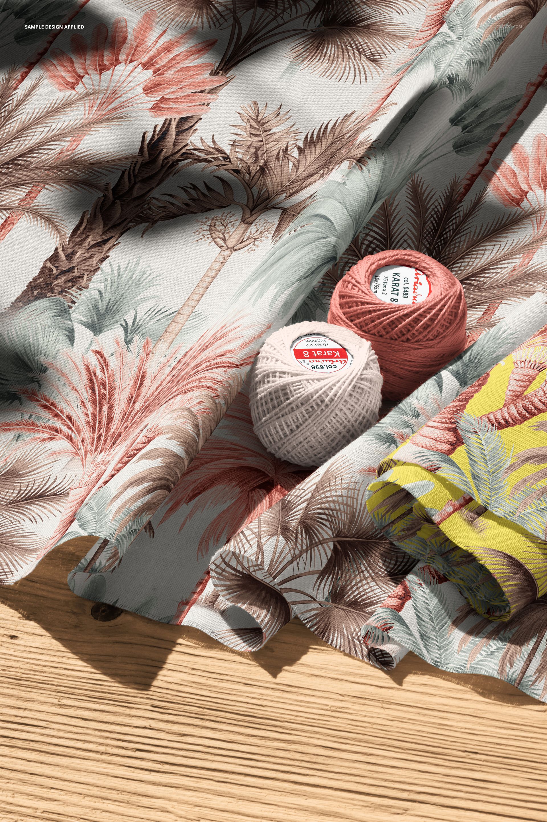 PSD mockup featuring cotton fabric with soft botanical print, accompanied by crochet threads and fabric folds in natural light.