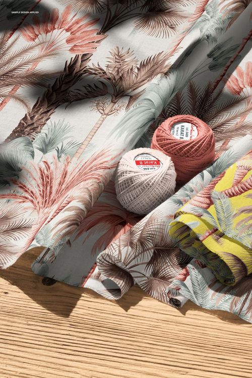 PSD mockup featuring cotton fabric with soft botanical print, accompanied by crochet threads and fabric folds in natural light.
