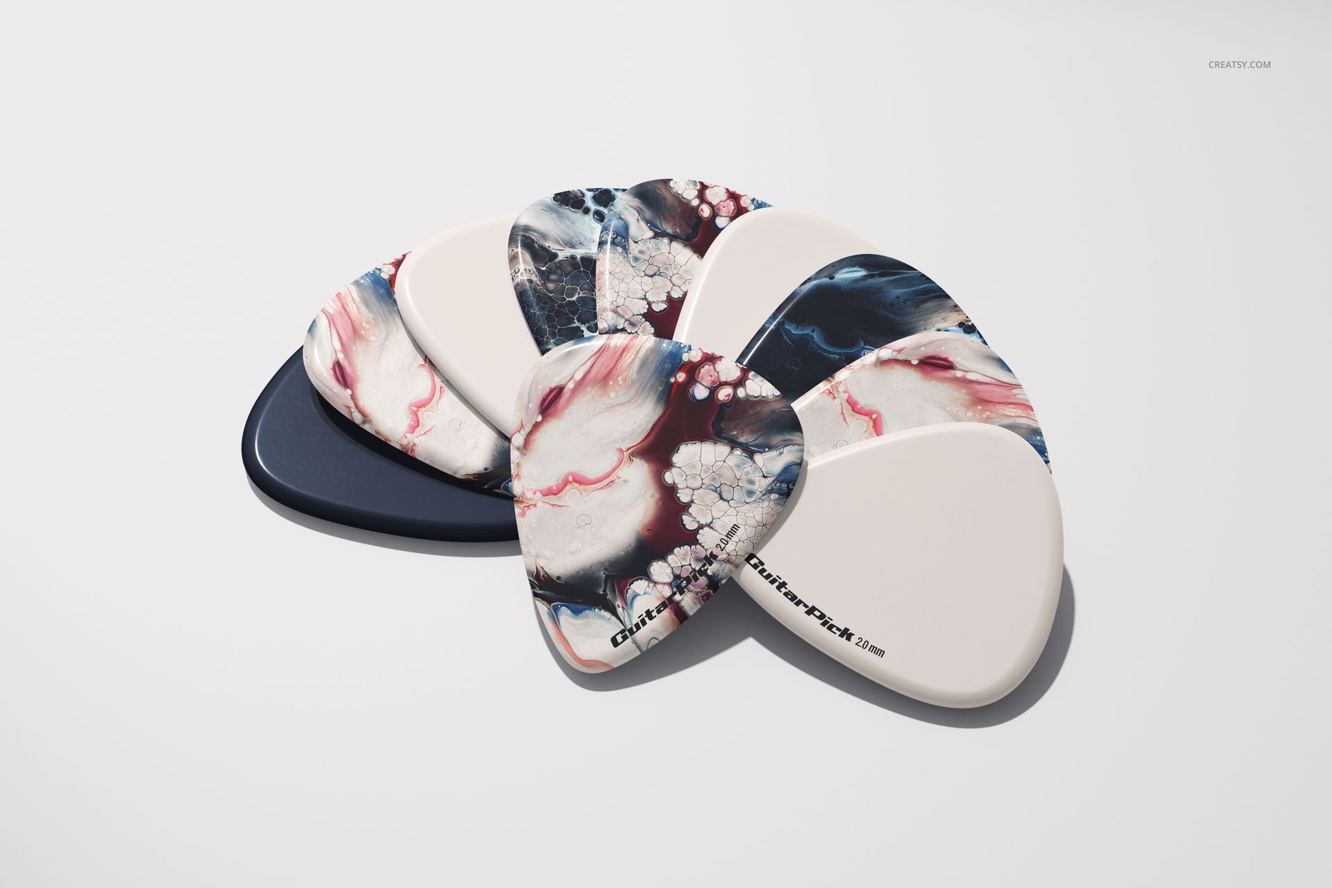 PSD mockup showing assorted guitar picks, some with artistic abstract designs and others in solid shades, laid out side by side.