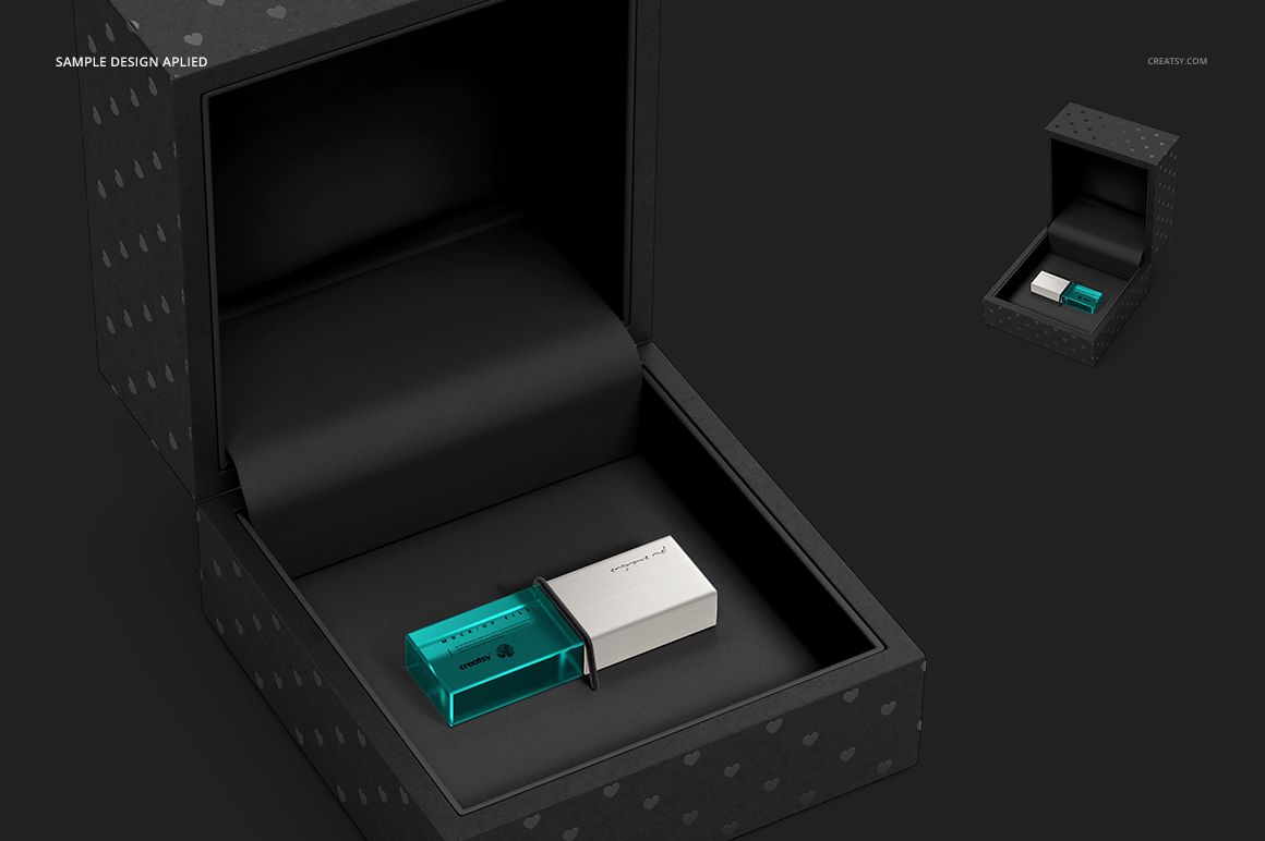 Front view of a black acrylic slide box mockup containing two USB drives in turquoise and white on a dark background.