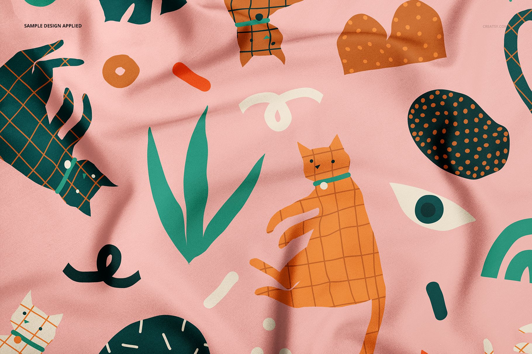 Close-up of a pet bandana mockup featuring orange cats, green plants, and geometric shapes on a pink background.