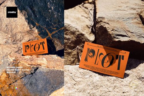 PSD mockup of a stationery business card set on coarse, rust-toned rocks in an outdoor environment.