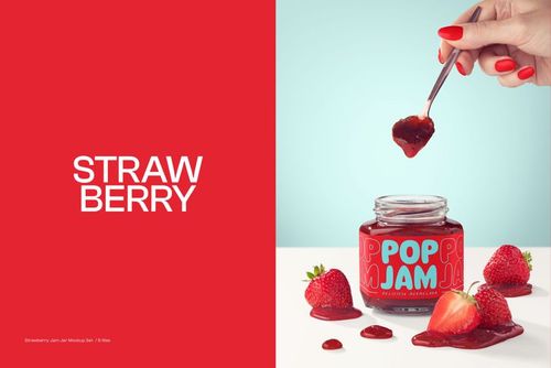 Jam jar mockup featuring a spoon with jam, scattered strawberries, and a vibrant label on a white surface.