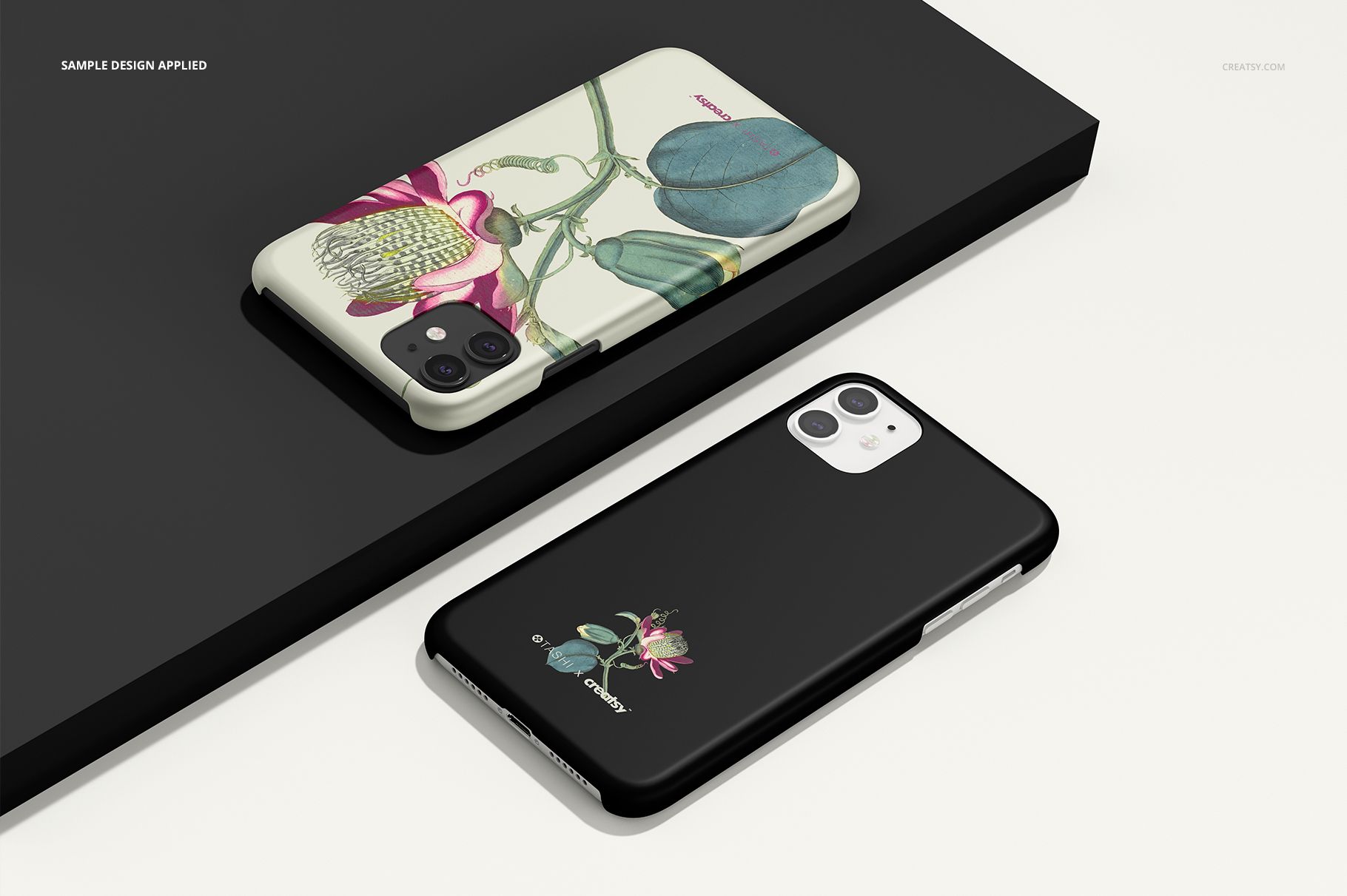 Pair of iPhone 11 matte cases with plant illustrations, arranged on a dark rectangular base in a mockup scene.