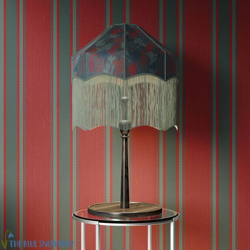 Table lamp mockup with a tasseled shade featuring a floral pattern, placed on a round glass table against a striped wallpaper.