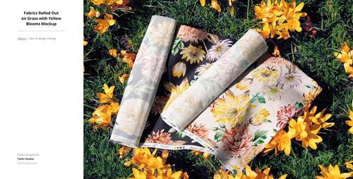 Outdoor mockup showing fabric rolls with various flower prints placed on grass among yellow blooming flowers.