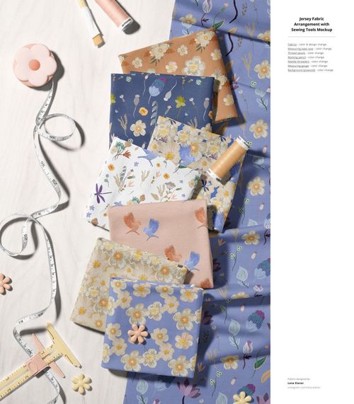 PSD mockup of layered jersey fabric swatches in blue and neutral shades, surrounded by sewing accessories and tools.