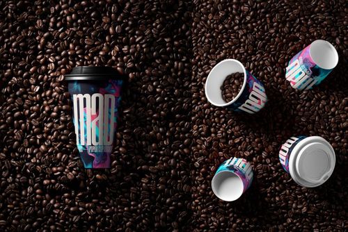PSD mockup featuring multiple paper cups with vibrant patterns, placed among scattered coffee beans in overhead and angled views.