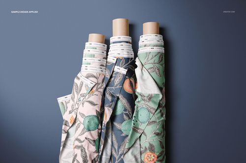 Fabric rolls mockup featuring floral designs in light pink, dark blue, and green, arranged upright with visible cardboard cores.