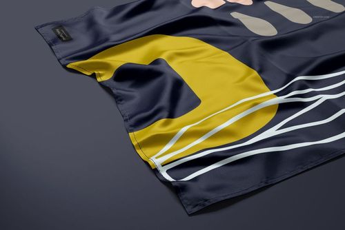 Narrow hem silk scarf mockup showing bold yellow and white patterns on navy fabric, displayed from a side perspective.