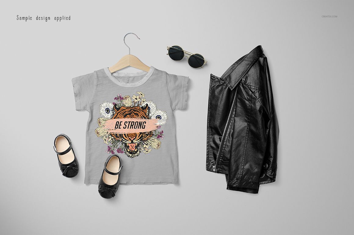 Girls chic set mockup featuring a gray t-shirt with a tiger graphic, black shoes, sunglasses, and a leather jacket on a light background.