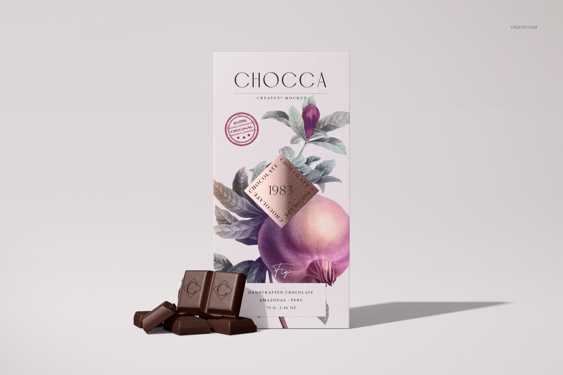 Front view of a chocolate bar packaging mockup with botanical illustration, accompanied by chocolate pieces on a light surface.