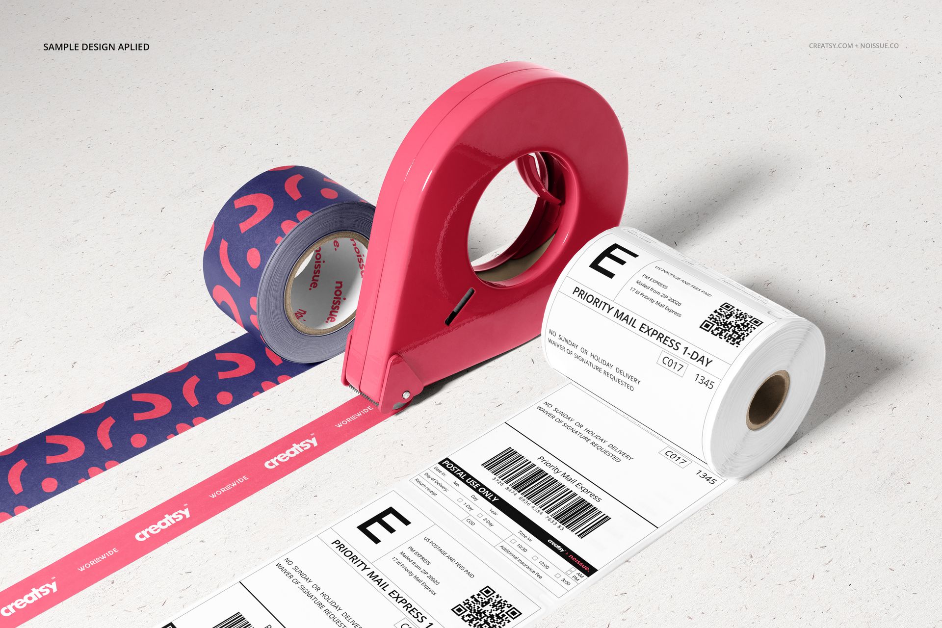 Front view of shipping labels mockup set with printed label roll, pink tape dispenser, and patterned tape on light surface.