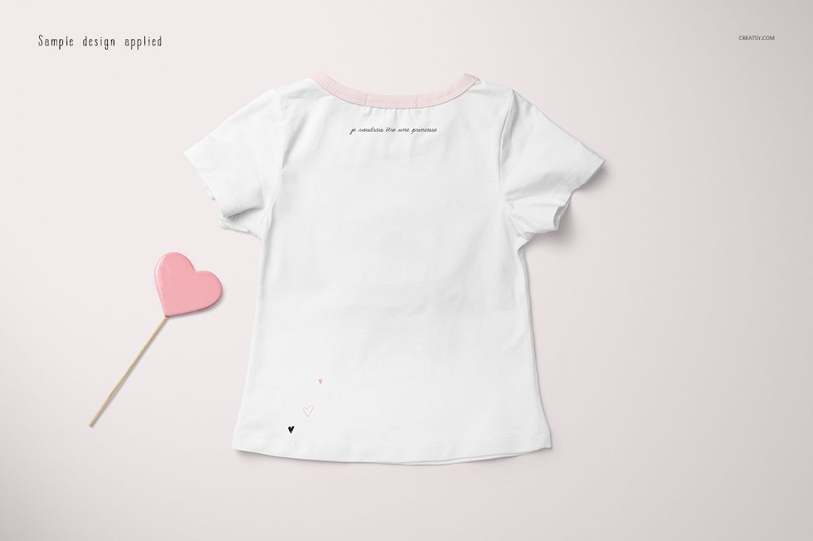 Girls T-shirt mockup featuring a white short-sleeve shirt with pink accents, shown from the back on a light surface.