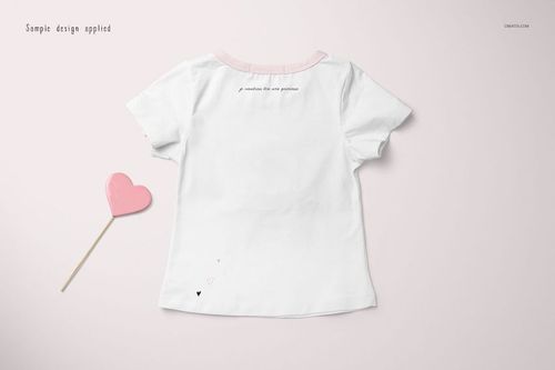 Girls T-shirt mockup featuring a white short-sleeve shirt with pink accents, shown from the back on a light surface.