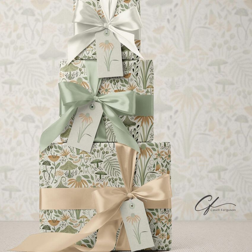 Stack of three Christmas presents mockup wrapped in floral patterned paper with pastel green and cream ribbons and gift tags.