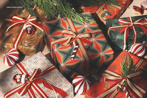 Christmas gift boxes with festive patterns and ribbons arranged under a tree, viewed from above in a PSD mockup scene.