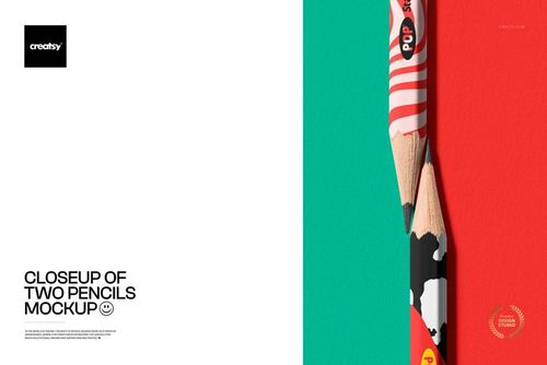 Close-up view of two pencils with colorful patterns, positioned vertically on a split teal and white background.