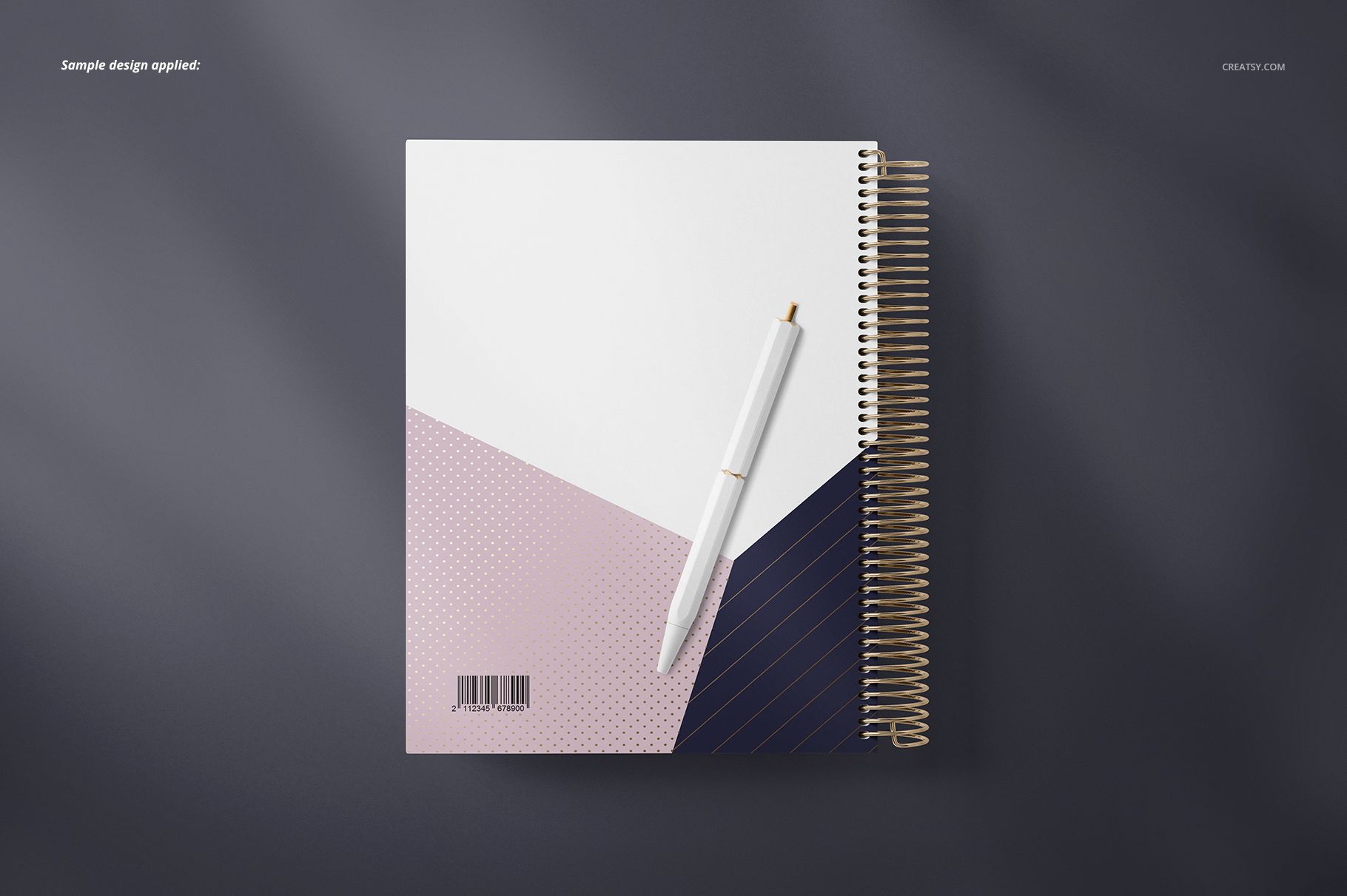 Stationery mockup featuring a square coil-bound planner with abstract color blocks and a gold spiral, top perspective.