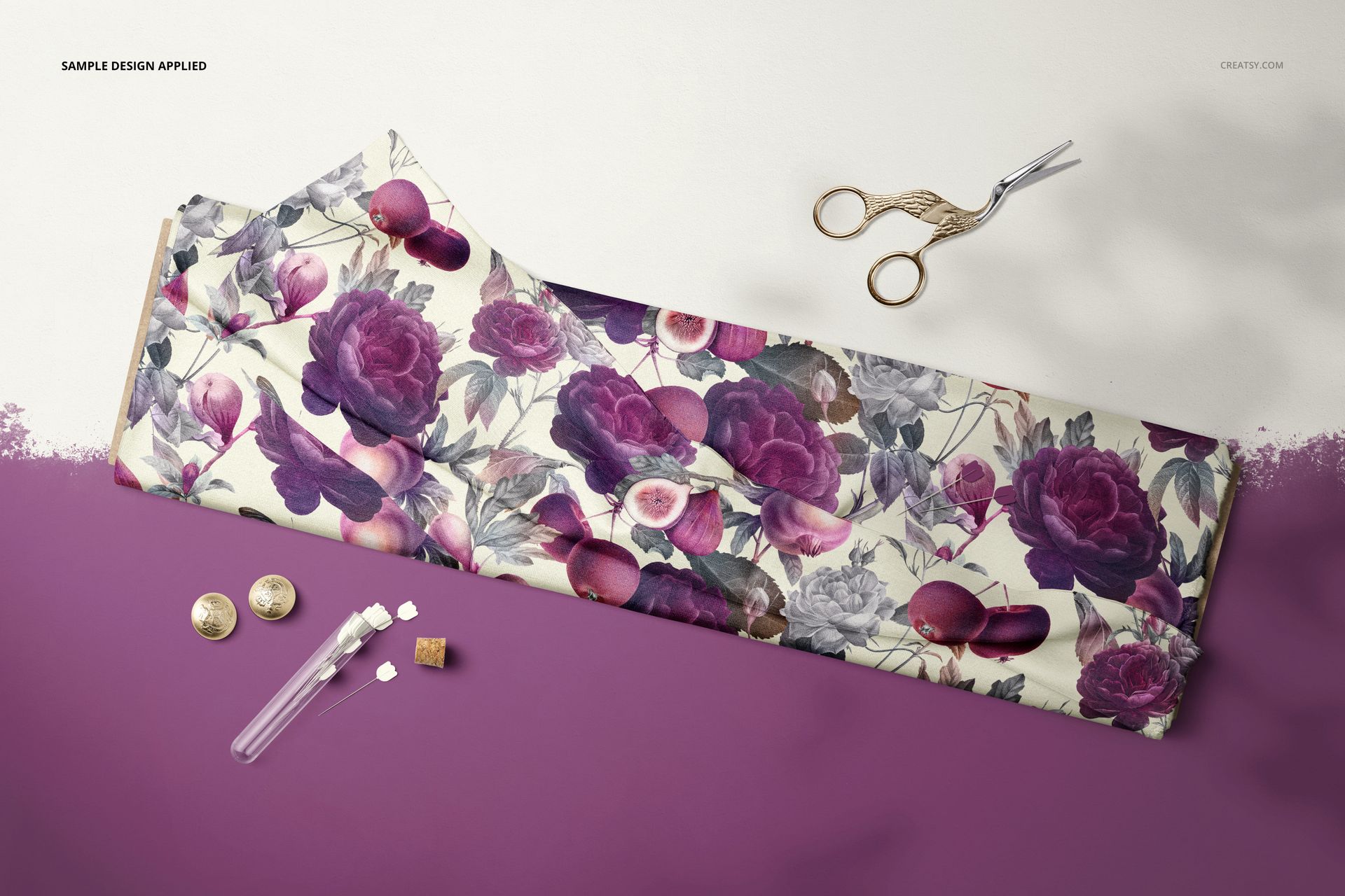 Fabric bolt mockup displayed from above, featuring purple floral designs and accompanied by tulip pins and scissors.