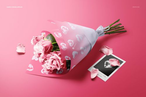 PSD mockup showing a bouquet of pink roses in decorative wrapping paper, with petals and a card on a pink backdrop.