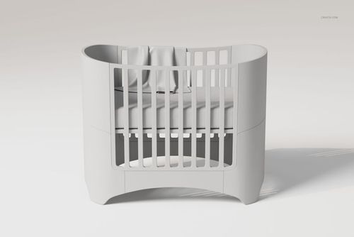 Modern white crib with rounded edges and vertical slats, featuring a small baby blanket draped inside, front view.