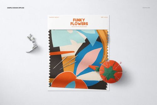 Fabric swatch mockup featuring an abstract colorful pattern, front view with sewing pins and an orange pincushion.