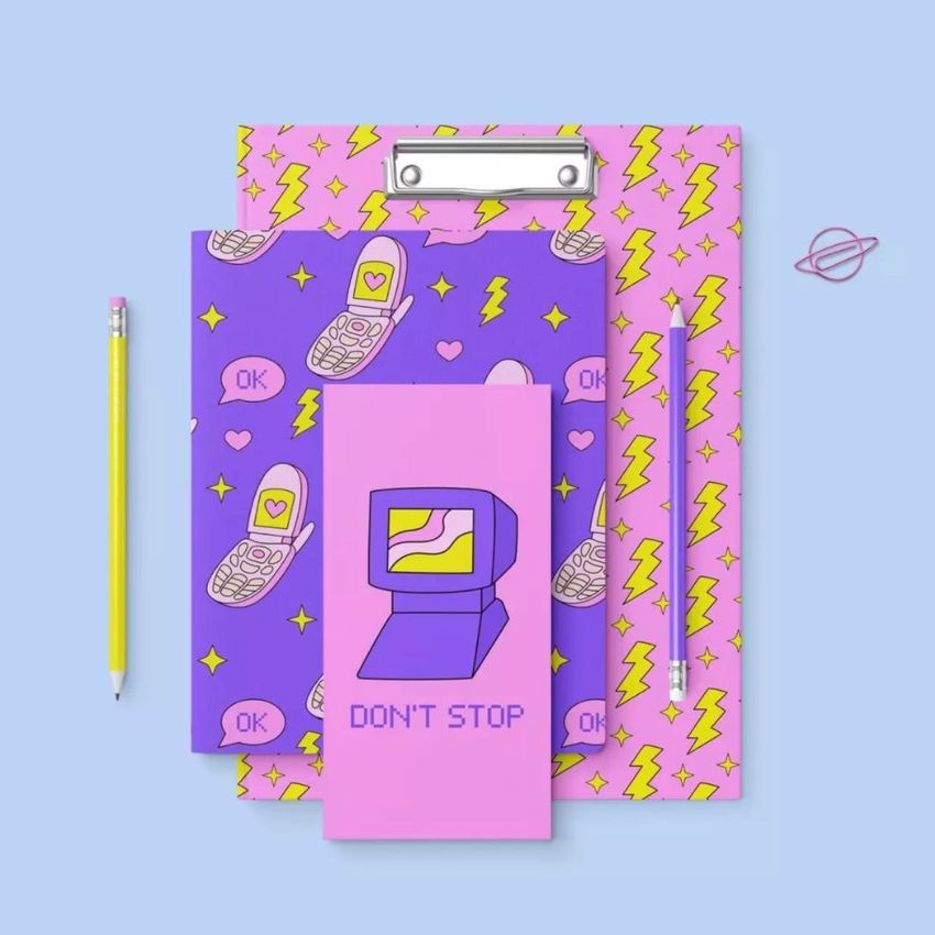 Stationery set mockup featuring a clipboard, notebook, and pencil with retro patterns in purple, pink, and yellow on a blue background.