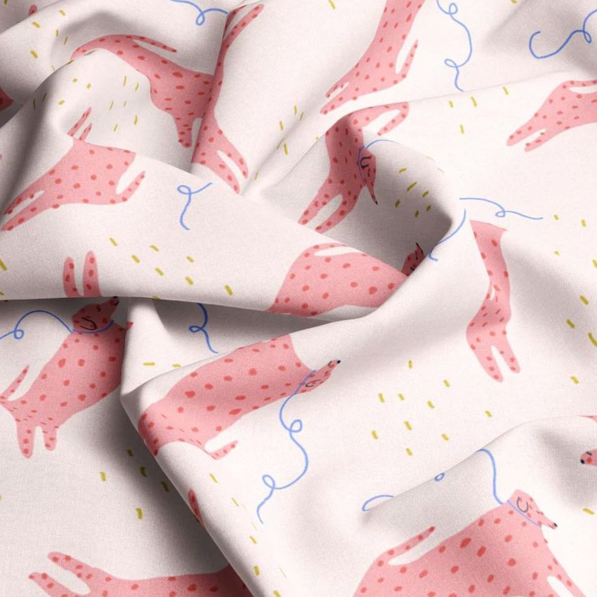 Fabric mockup showing a close-up of white cotton material with a playful pink animal pattern and scattered yellow and blue accents.