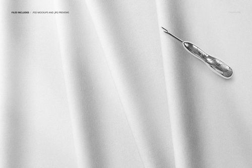 Light gray folded fabric mockup shown from above, featuring a seam ripper tool on the upper right corner.