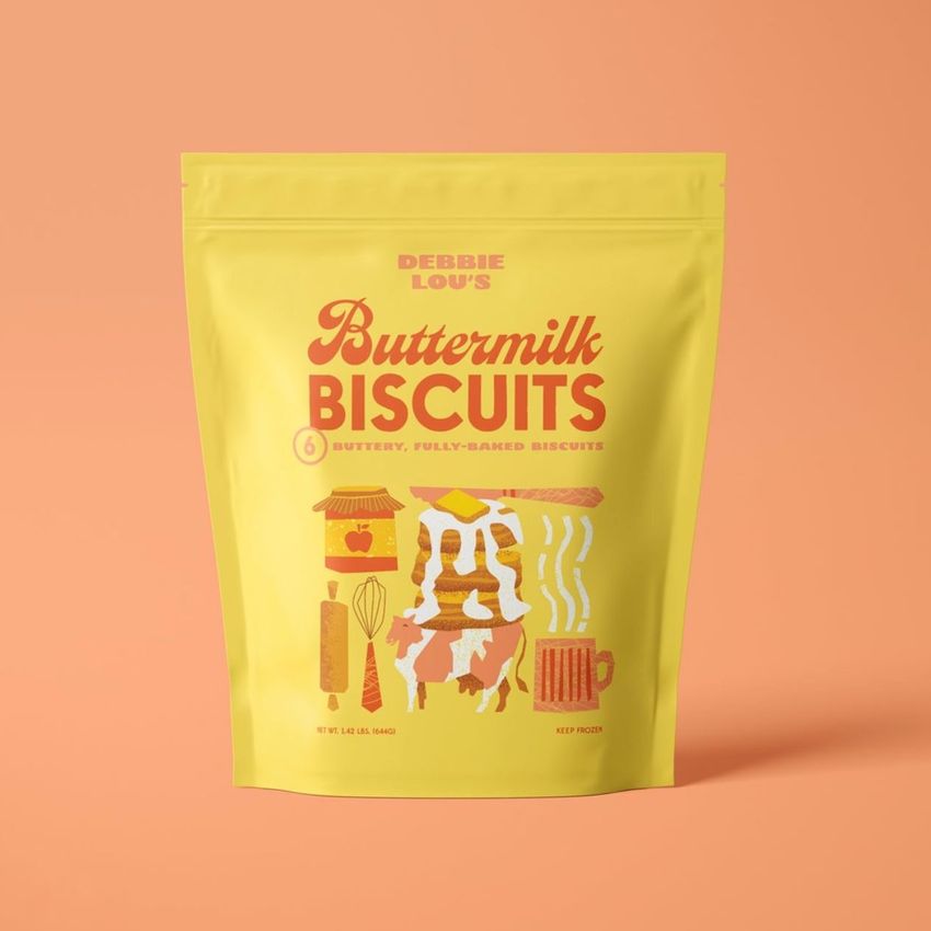 Stand up zip lock pouch mockup featuring a yellow bag with colorful biscuit-themed graphics and text on a peach background.