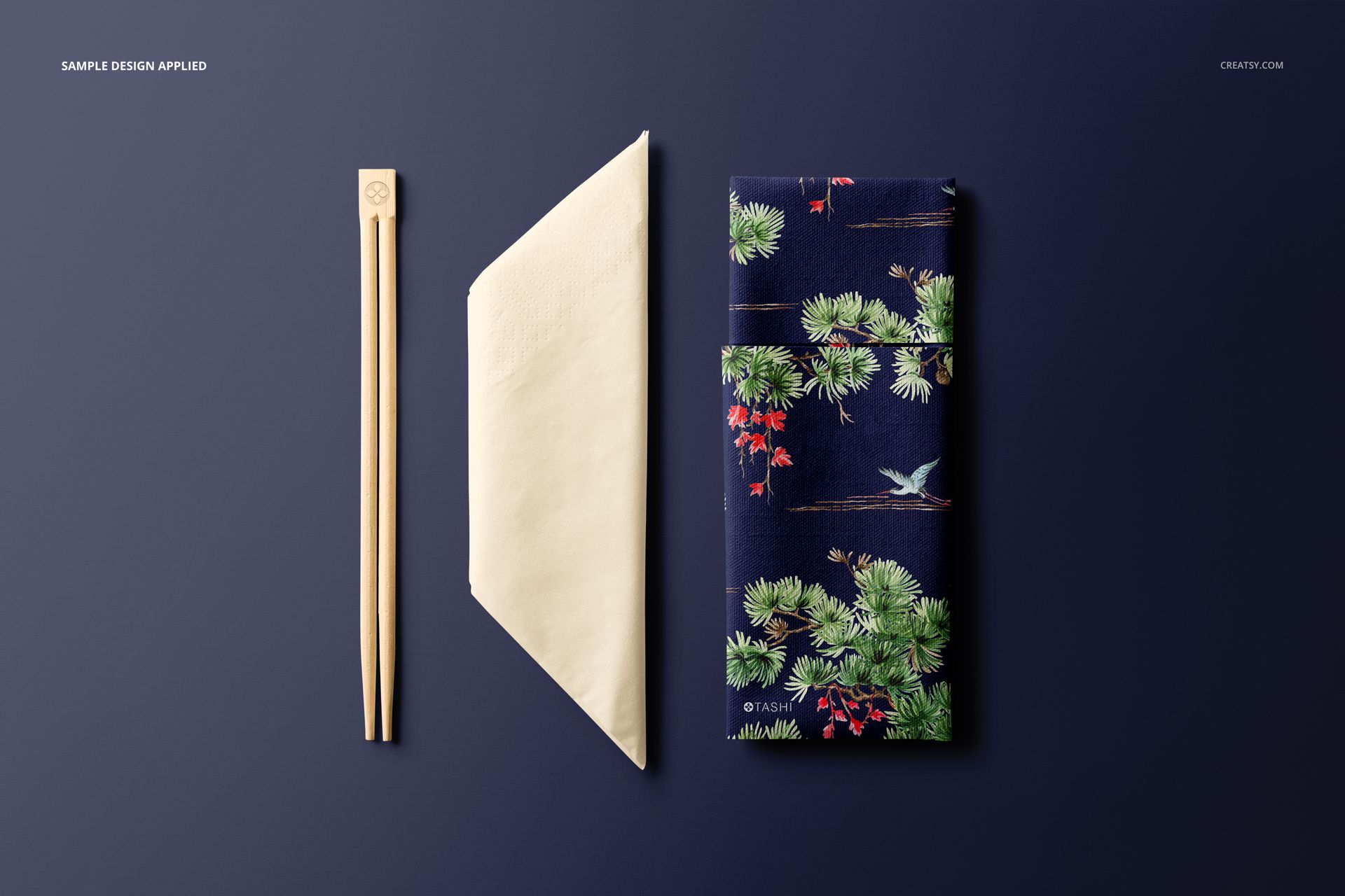 PSD mockup set showing chopsticks, a simple napkin, and a colorful patterned napkin arranged on a navy background.