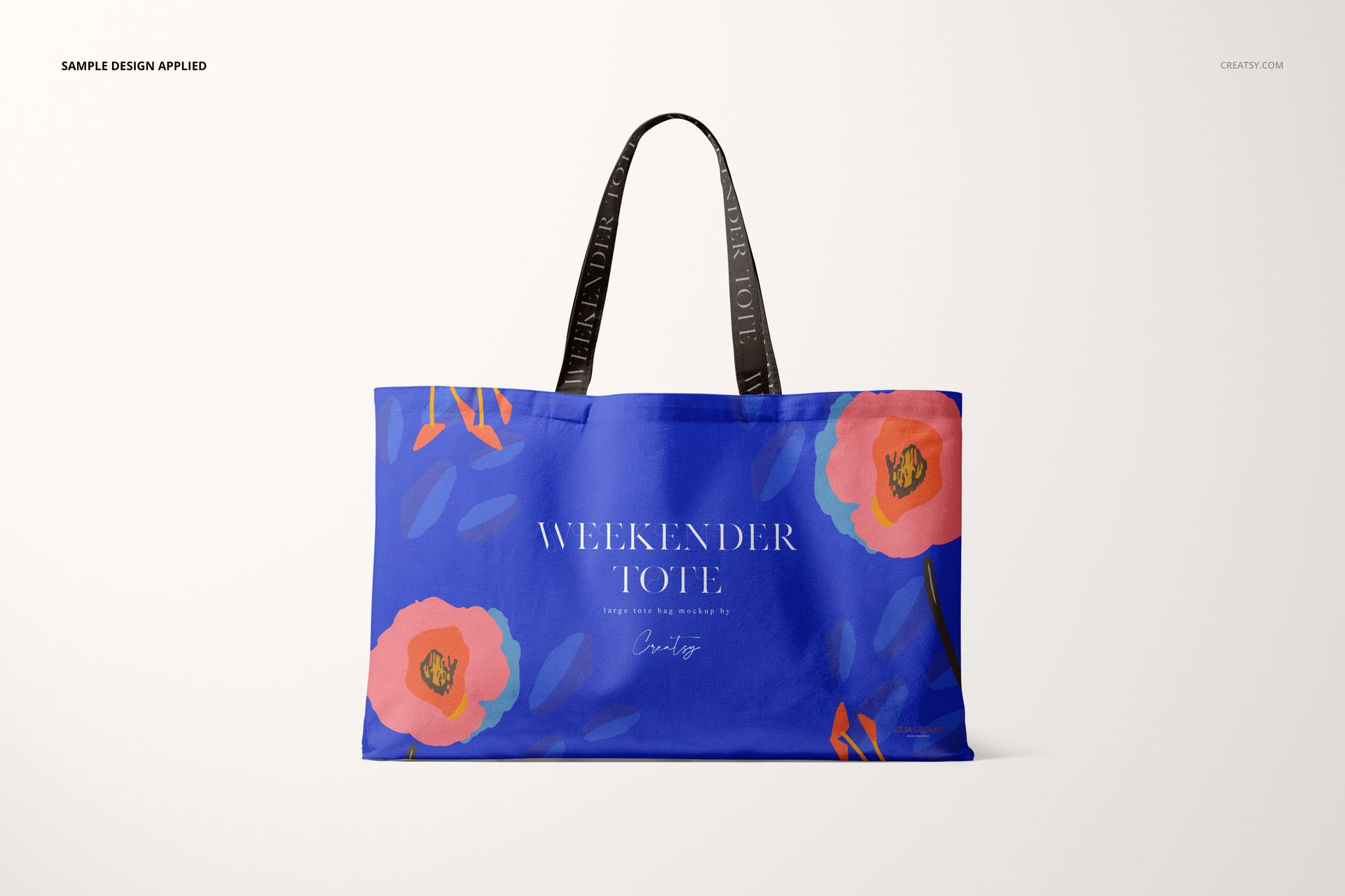 Front view of a large tote bag mockup with blue fabric, orange flowers, and black handles on a light backdrop.
