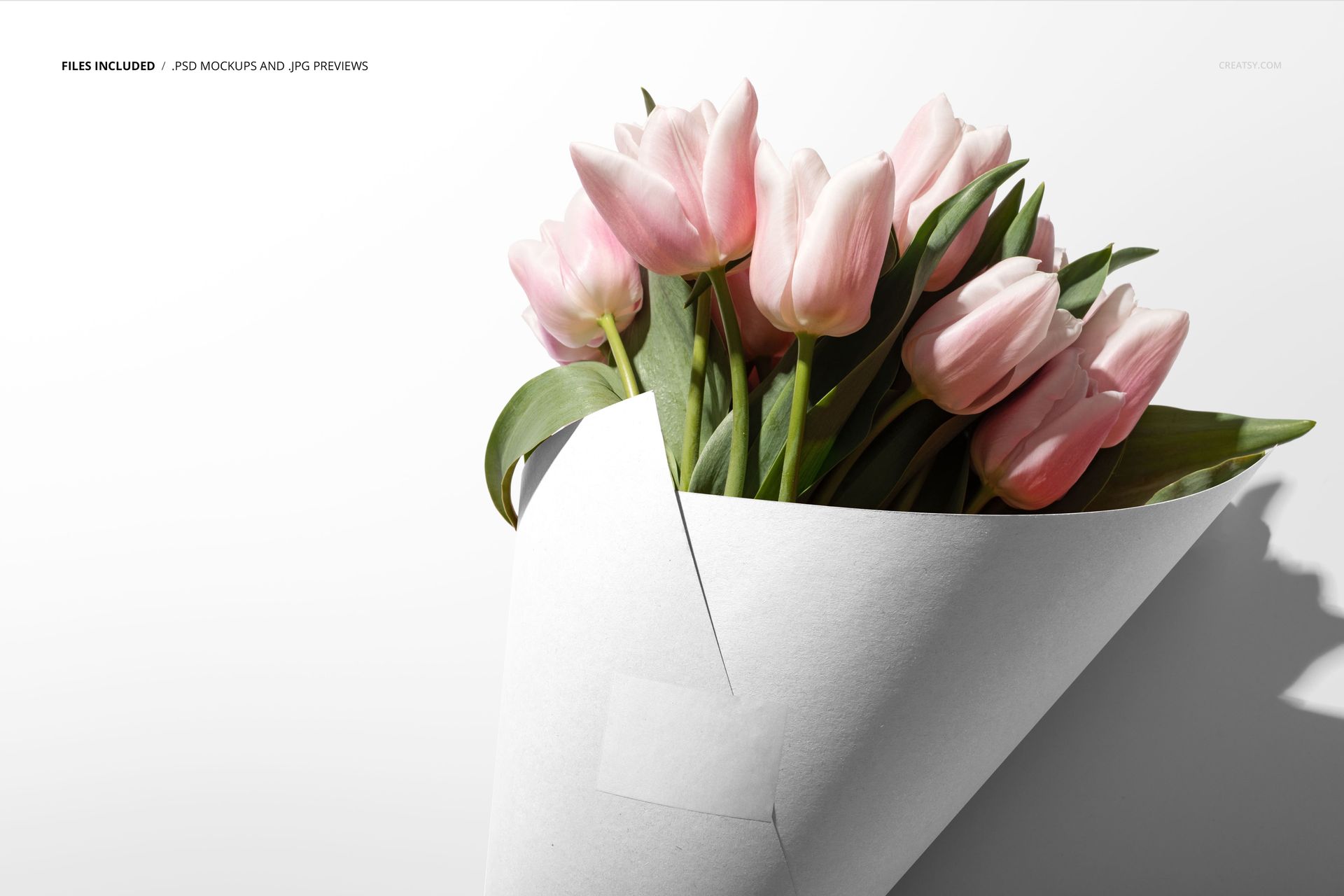 PSD mockup showing a bouquet of pale pink tulips wrapped in a white cone, photographed against a studio backdrop.