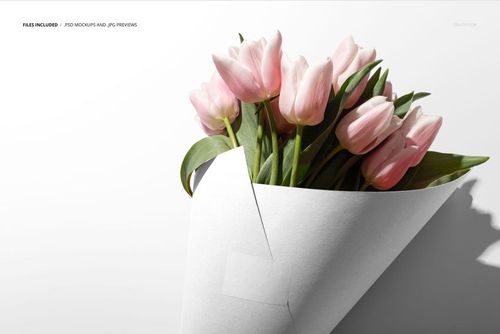 PSD mockup showing a bouquet of pale pink tulips wrapped in a white cone, photographed against a studio backdrop.