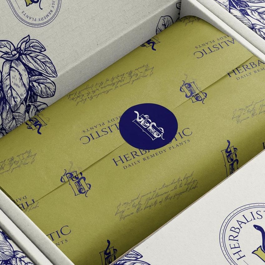 Mailing box mockup featuring yellow tissue paper with handwritten text and botanical illustrations, viewed from above.