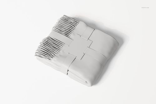 Folded blanket with fringe edges and a rectangular label, shown from a top angle on a plain white background.