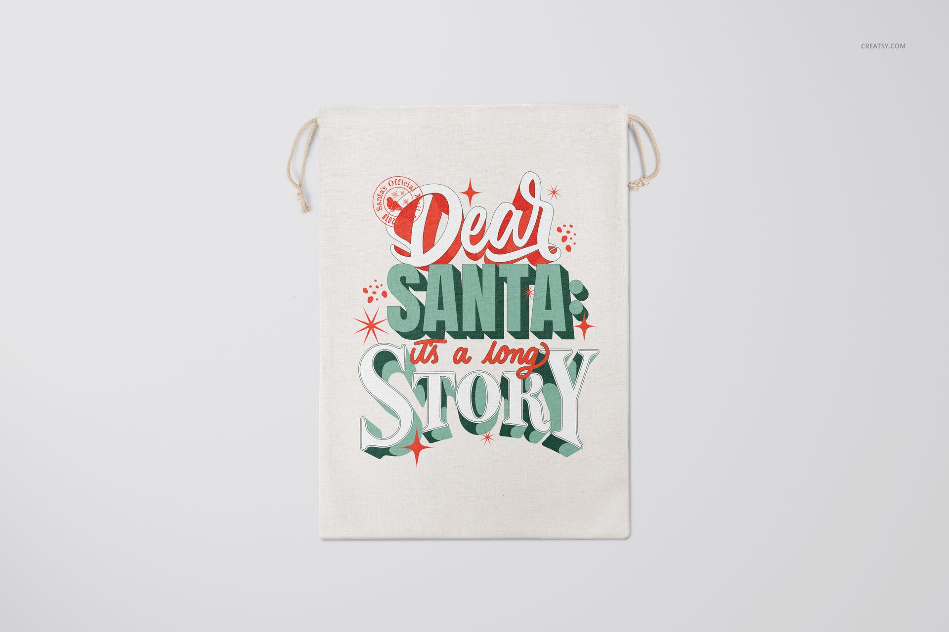 Christmas-themed drawstring bag mockup featuring bold red and green text and decorative elements on a light fabric surface.
