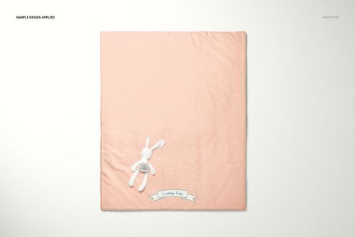 Flat lay of a peach baby duvet cover mockup with a small white stuffed rabbit and a decorative banner at the bottom.