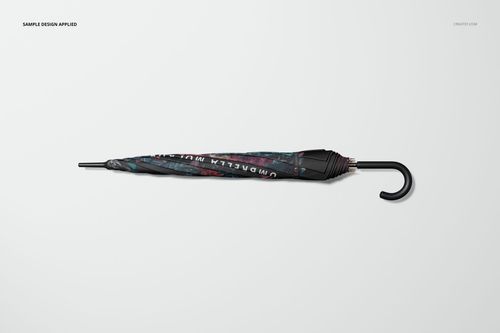 Umbrella mockup shown from a side view, closed and decorated with abstract dark patterns, on a neutral backdrop.