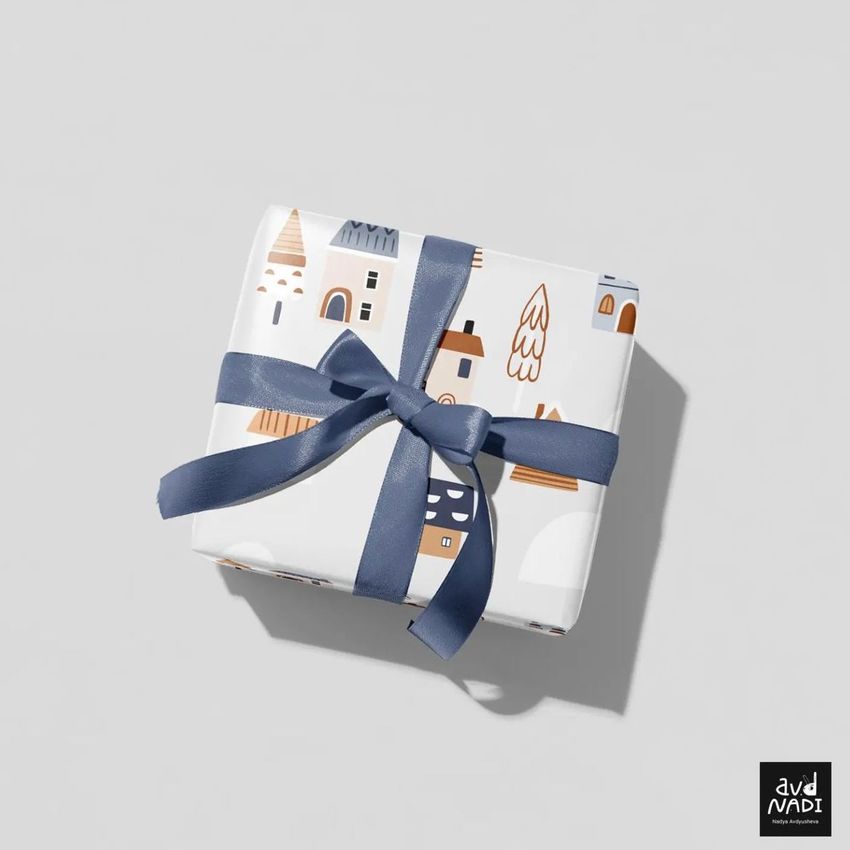Wrapping paper mockup featuring a square gift box with a blue ribbon, decorated with simple holiday-themed illustrations on a light background.