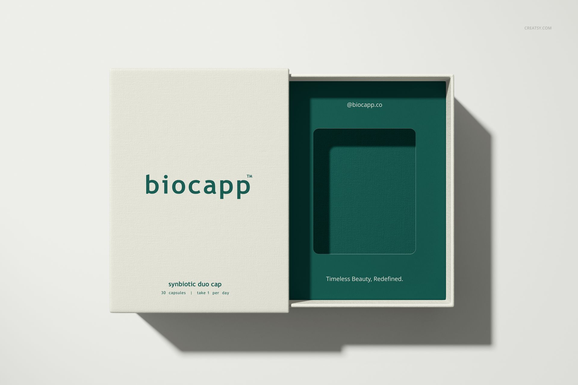 Rectangular packaging box mockup with lid partially removed, revealing a green insert tray and simple text.