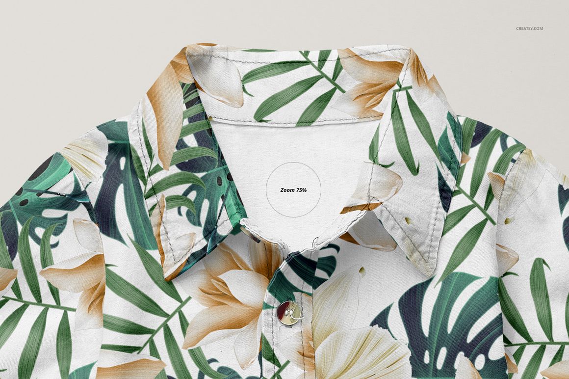 Close-up front view of a baby jeans dress mockup with a tropical leaf and flower pattern in green and beige tones.