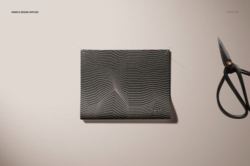 Mockup of a fabric sample with abstract linear design, displayed flat with visible pins and scissors on a neutral background.