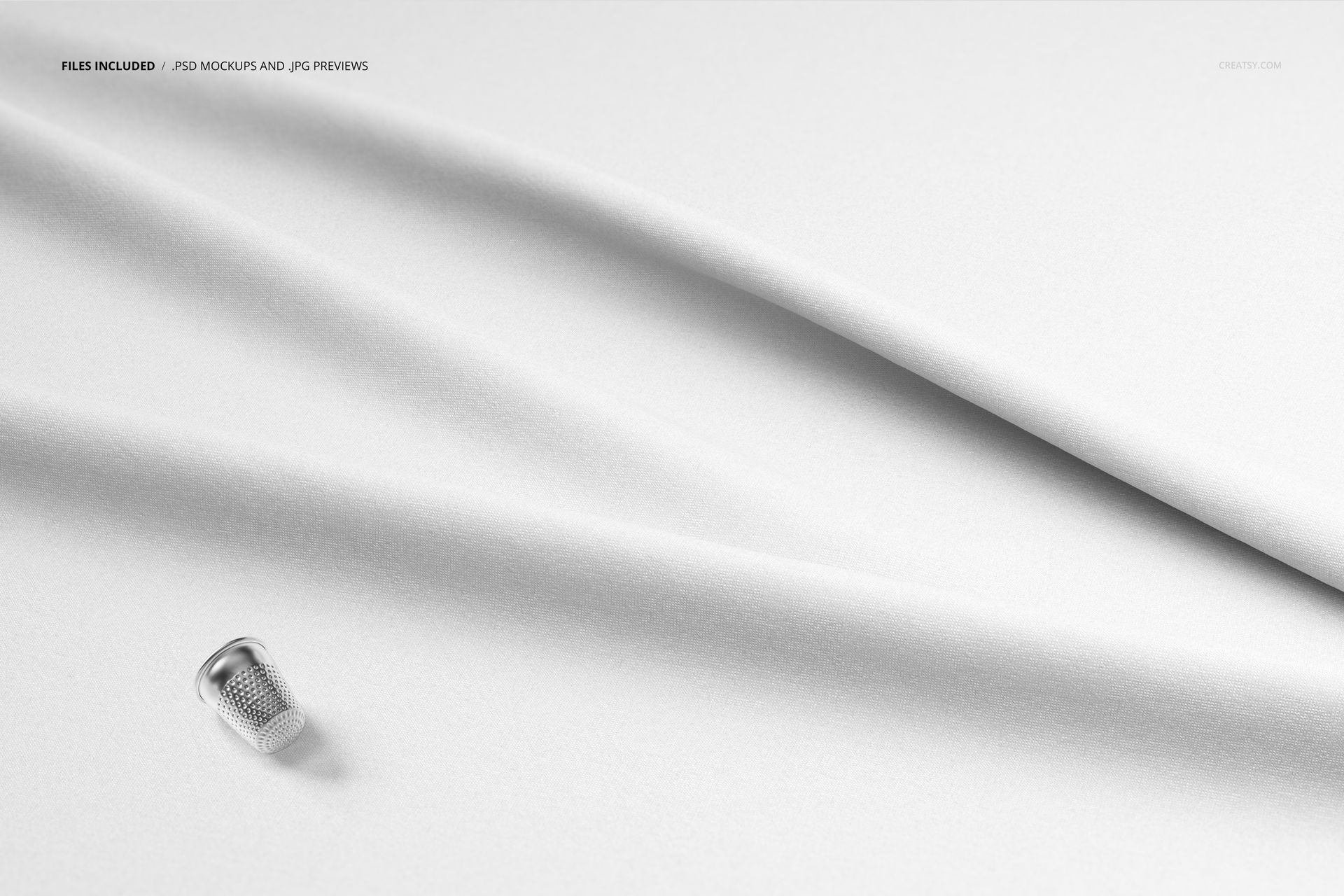 Top view of smooth white textile with gentle creases and a silver thimble placed near the edge, fabric mockup scene.