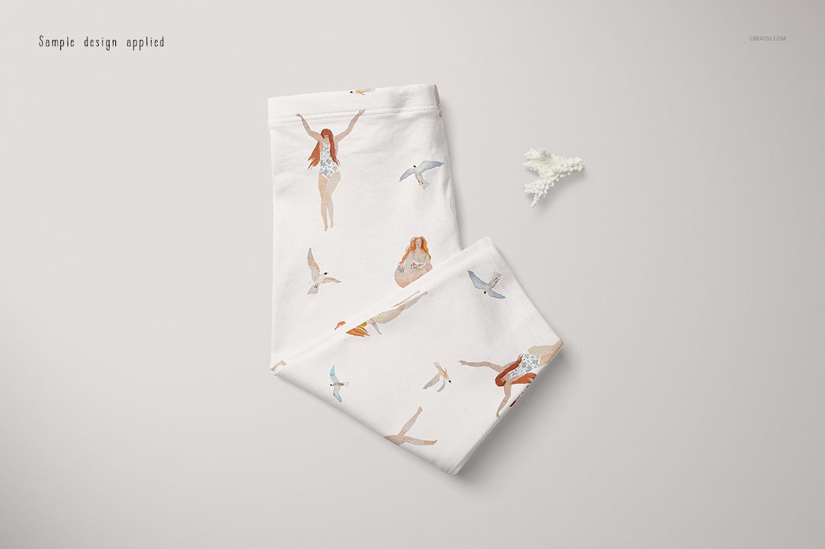 Folded baby leggings mockup featuring whimsical swimmer and bird patterns on a white background, top view.
