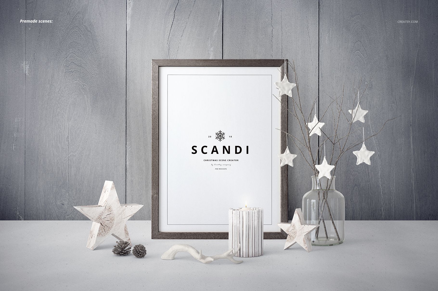 Front view of a Christmas-themed mockup featuring a framed print, white paper stars, candles, and pine cones.