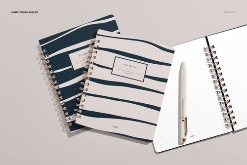 Little coiled notebook PSD mockup featuring two closed notebooks with dark blue stripes and one open beside a pen.