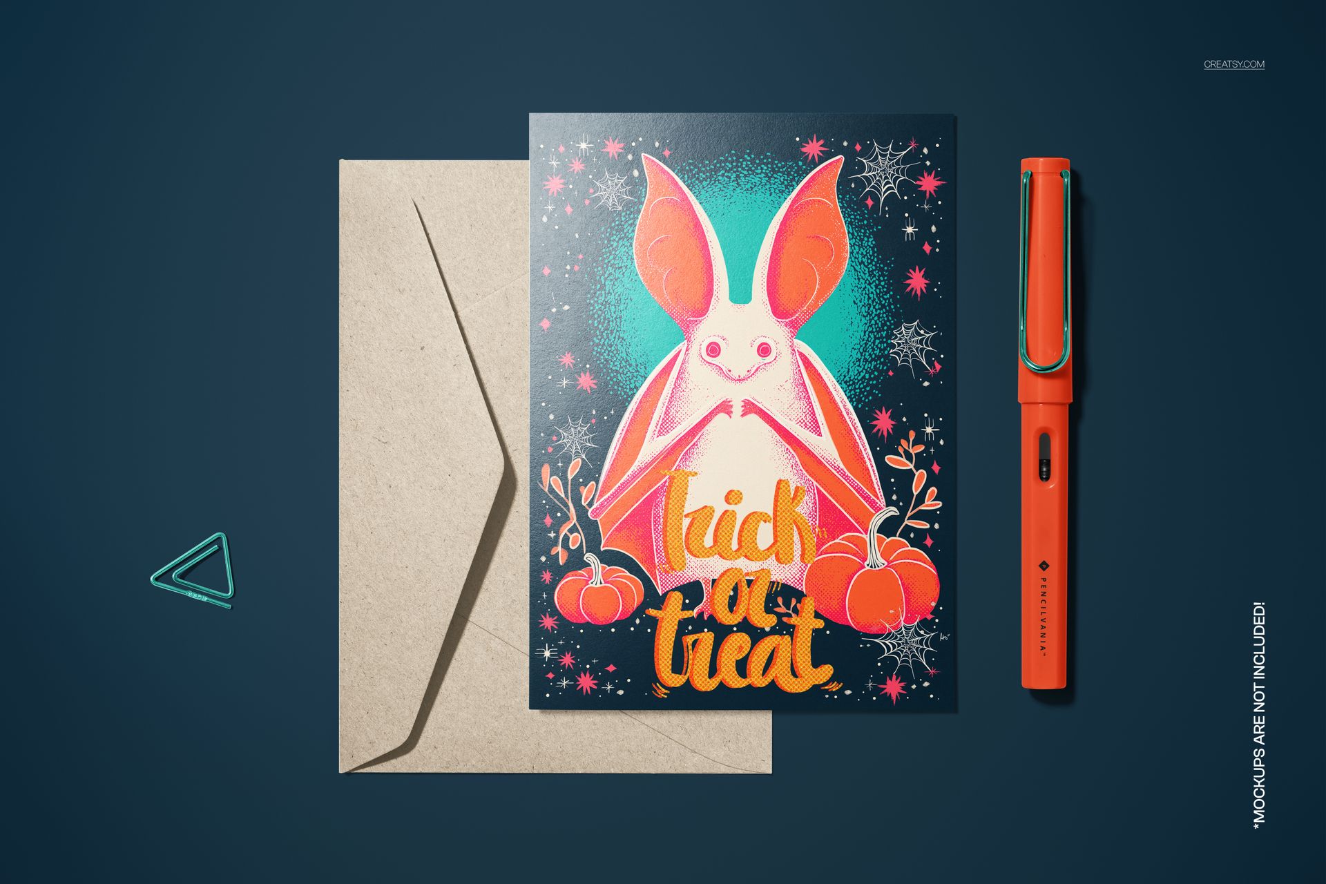 Mockup of a 5x7 card featuring a neon bat, orange pumpkins, and festive stars, shown beside a brown envelope and pen.