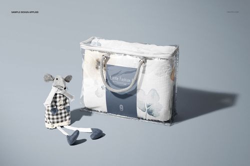Newborn swaddle wrap mockup displayed in a clear plastic bag with a blue label, next to a soft fabric mouse toy.